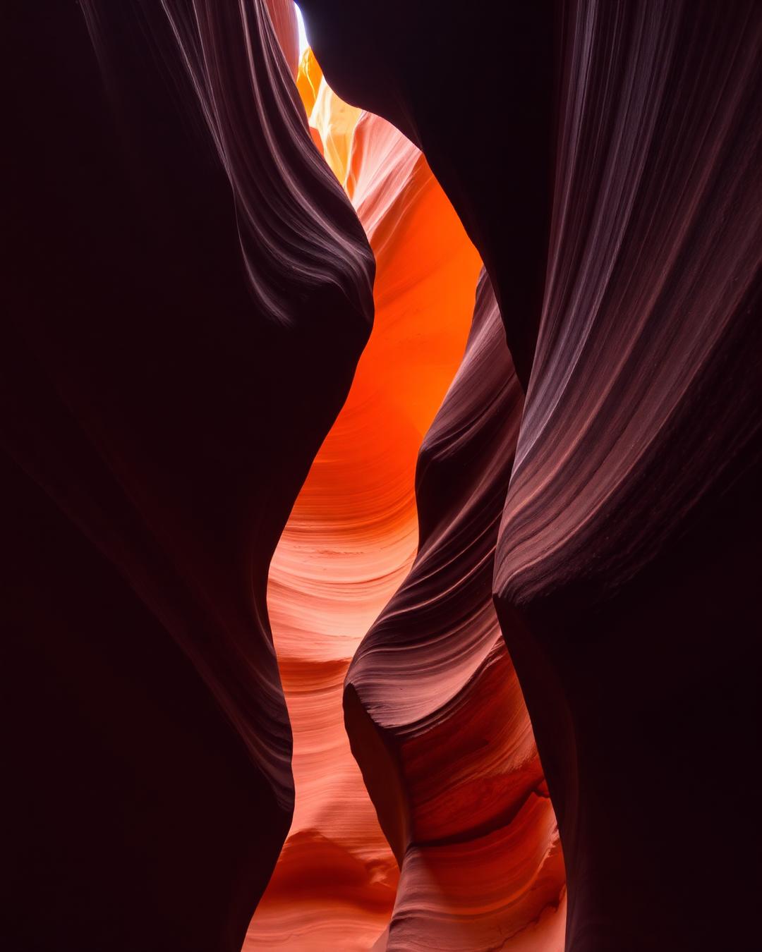 Narrow slot canyon with glowing orange light on red sandstone walls